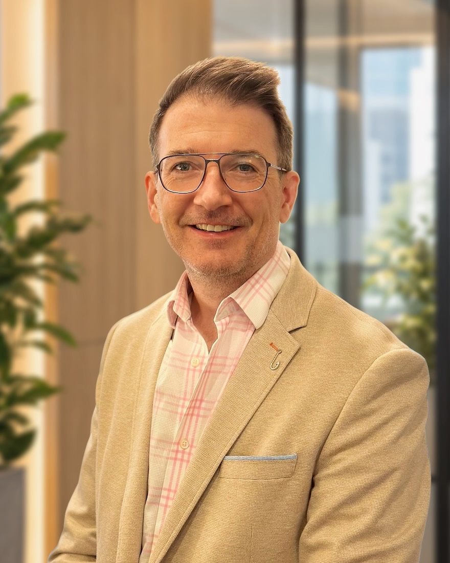 Colum Furey wearing glasses and a light jacket.